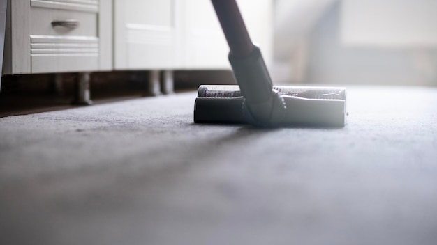 Un limpiador de alfombras está limpiando el suelo con un rodillo.