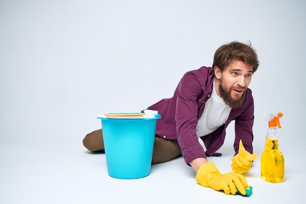 Limpiador en guantes de goma lavando pisos quehaceres domésticos fondo claro