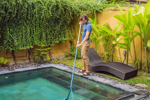 Limpiador de la piscina Hombre con camisa azul con equipo de limpieza para piscinas Servicios de limpieza de piscinas