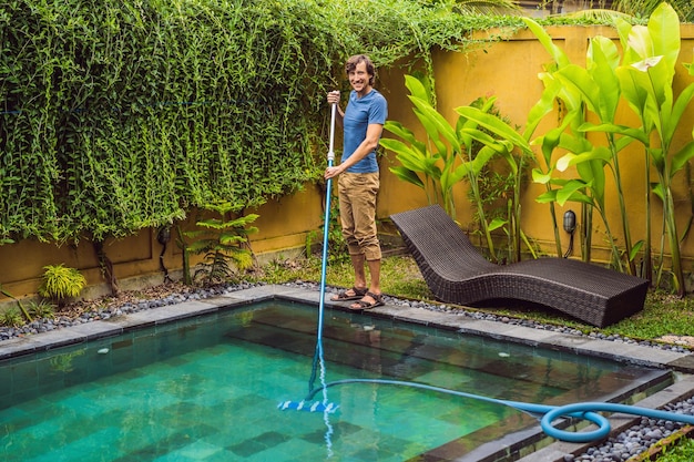 Limpiador de la piscina Hombre con camisa azul con equipo de limpieza para piscinas Servicios de limpieza de piscinas