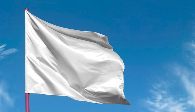 Limpiar la bandera blanca en blanco en el asta de la bandera contra el cielo azul,