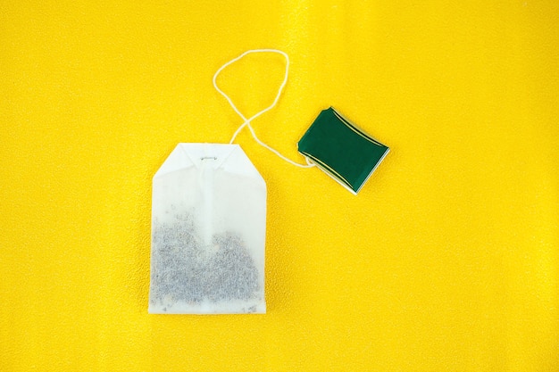 Foto limpiar la bolsita de té sobre un fondo amarillo
