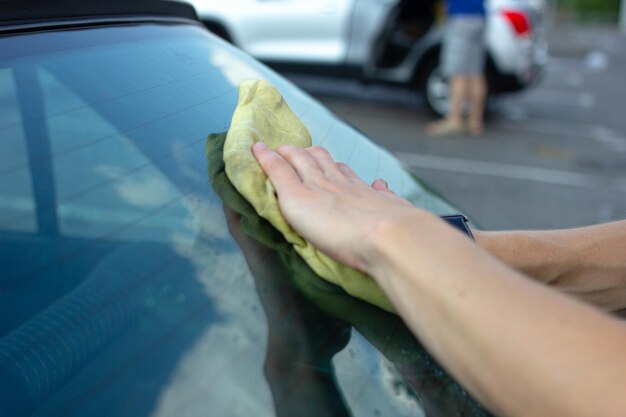 limpiar la carrocería del coche con un paño de microfibra después del lavado