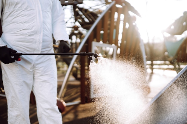 Foto limpiar y desinfectar el patio de recreo con productos químicos en aerosol para prevenir la propagación del coronavirus.