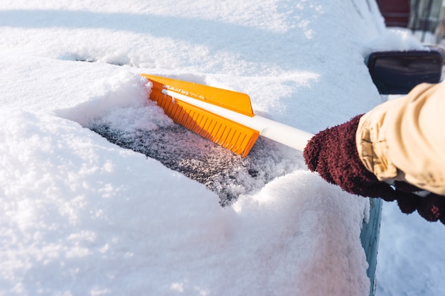 Limpiar la nieve de la carrocería de un automóvil