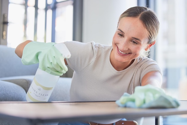 Limpiar el spray y el polvo con la mujer y la superficie de la mesa en el hogar para el servicio doméstico de higiene o la hospitalidad con guantes Limpieza de sonrisas y limpieza del mostrador de muebles en la sala de estar