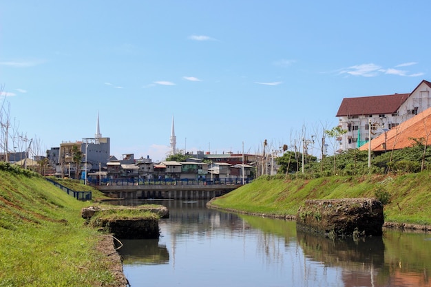 Limpie el río urbano con hierba verde en las orillas