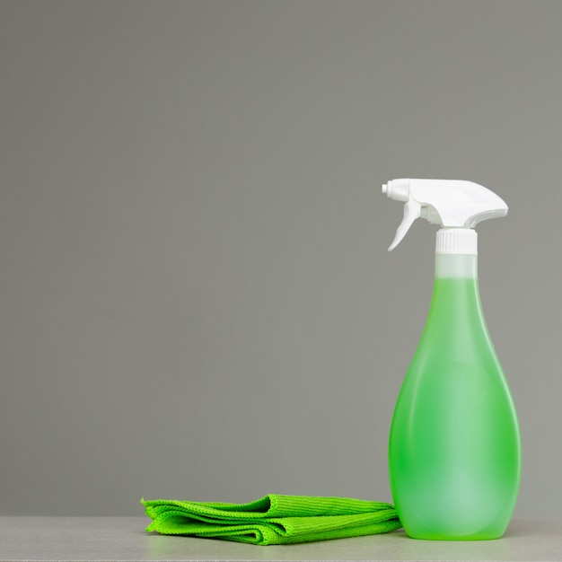 Limpieza de la botella de spray verde con dispensador de plástico y tela.