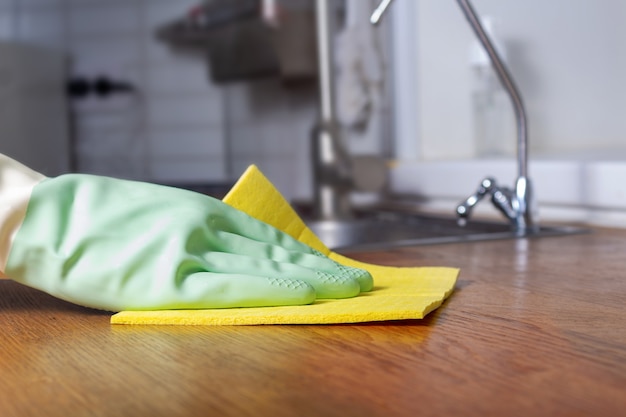 Foto limpieza de cocina con primer plano de guante de goma verde