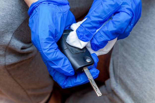 Limpieza, desinfección, limpieza del panel de teclas automáticas con una mano en un guante y una servilleta de cerca