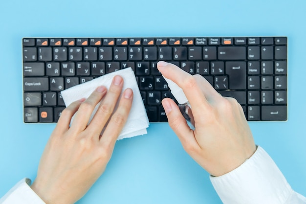 Foto limpieza y desinfección de virus corona en su espacio de trabajo. toallitas desinfectantes para limpiar la superficie del escritorio, el teclado y el mouse en la oficina. detener la propagación del coronavirus covid-19.