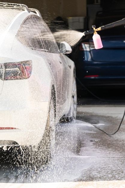Limpieza ecológica lavando un coche eléctrico en casa