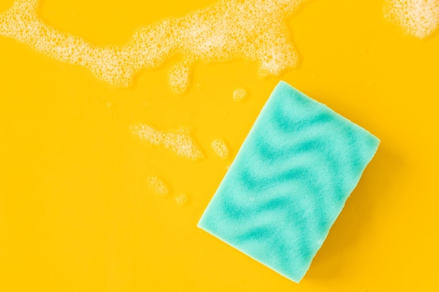 Limpieza de esponja azul y una espuma jabonosa sobre un fondo Concepto de limpieza servicio de limpieza