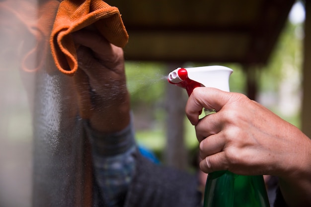 Limpieza del hogar rociado de una botella de spray antibacteriano para desinfectar contra virus