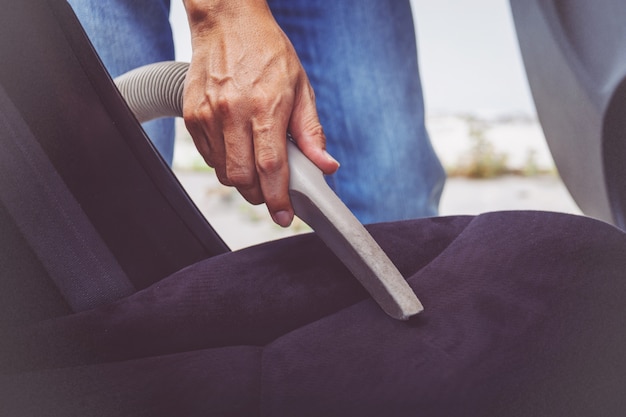 Foto limpieza hombre del interior del coche con aspiradora.