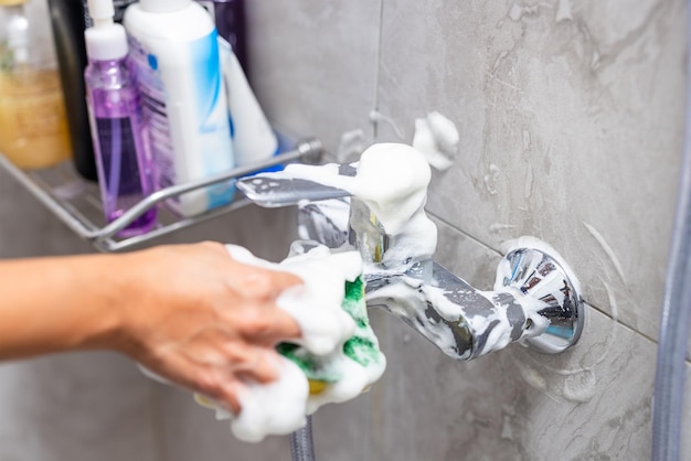 Limpieza de manchas de agua dura depositadas en el grifo del baño en el inodoro