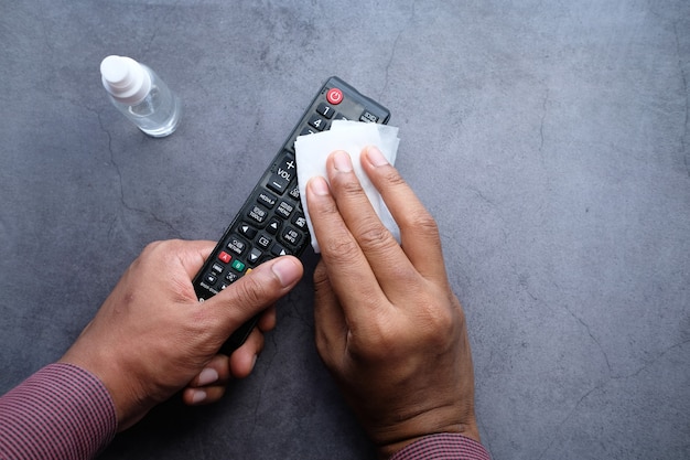 Limpieza del mando a distancia del televisor con un pañuelo de tela antibacteriano.