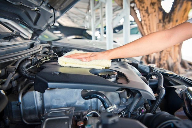 Limpieza manual del motor del coche con un trabajador de trapos