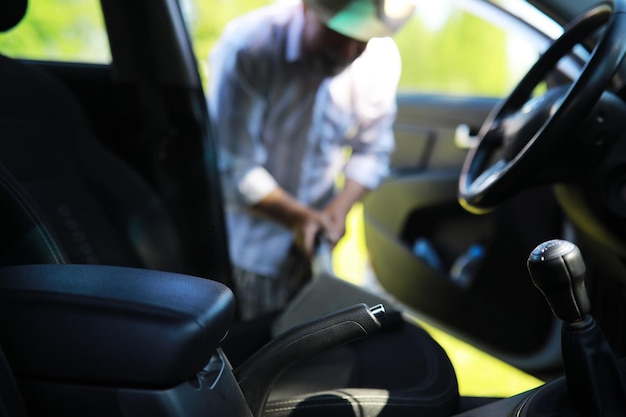 Limpieza de molduras automáticas Lavado manual de automóviles Un hombre canoso limpia su vehículo