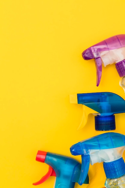 Foto limpieza de productos de botellas de spray sobre un fondo amarillo brillante