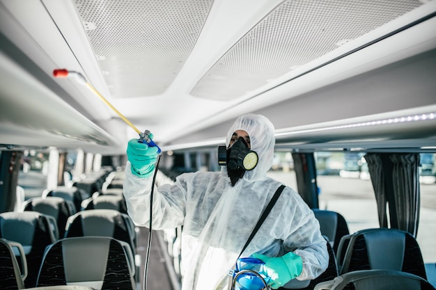 Limpieza química profesional de asientos de autobús. Desinfección de autobuses. Exterminador en ropa de trabajo.