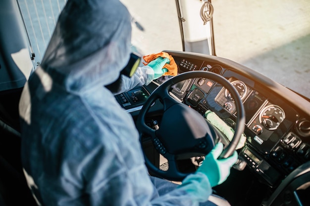 Limpieza química profesional de asientos de autobús. Desinfección de autobuses. Exterminador en ropa de trabajo.