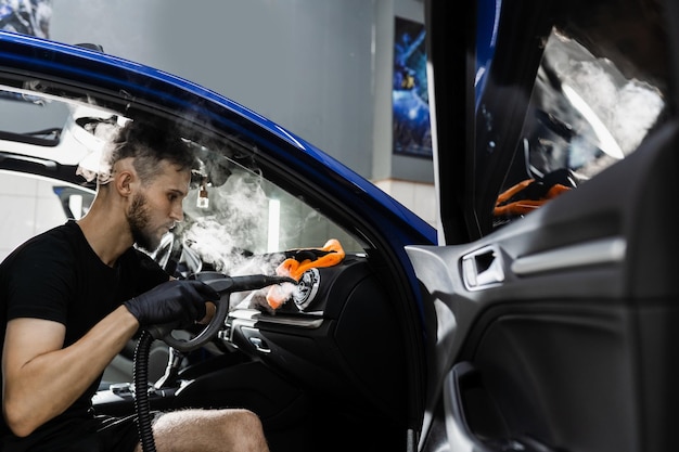 Limpieza a vapor del sistema de aire Trabajador en el servicio de limpieza de automóviles Limpie el interior del automóvil Detalle del interior del automóvil