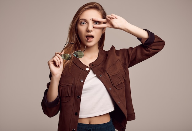 Linda adolescente en chaqueta de moda y gafas