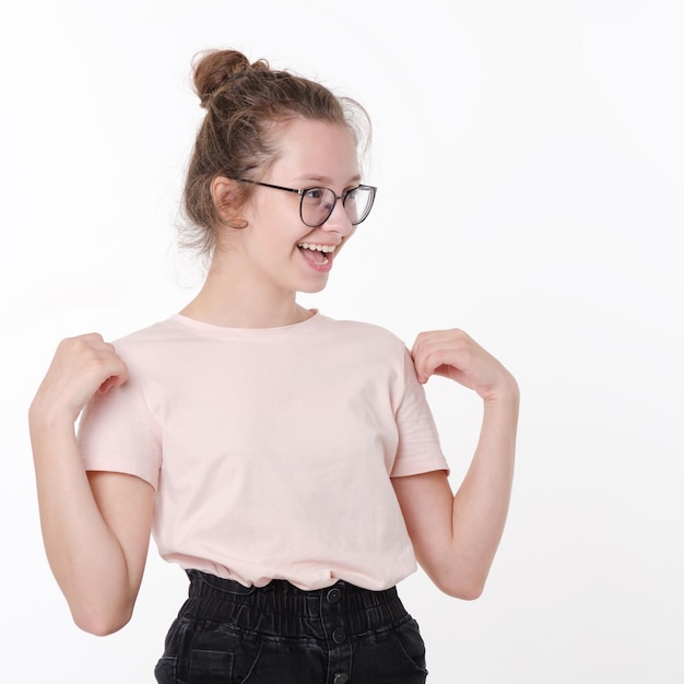 Linda adolescente feliz de óculos e camiseta sorrindo em fundo branco