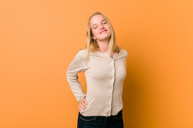 Linda adolescente posando de pie contra una naranja