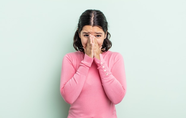 Linda adolescente se sentindo preocupada, esperançosa e religiosa, orando fielmente com as palmas das mãos pressionadas, implorando perdão