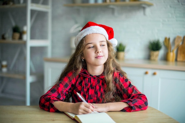 Foto linda adorable niña sonriente con sombrero de santa claus en casa