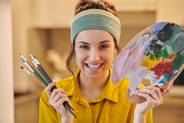 Linda artista femenina que se ve feliz y disfrutada