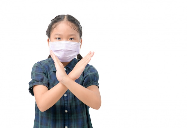 Linda asiática usa una máscara quirúrgica para protegerte contra los virus covid-19 y muestra un gesto con la mano para detenerse.