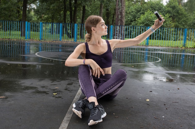 Linda atleta tirando uma selfie depois de um treino difícil no parque