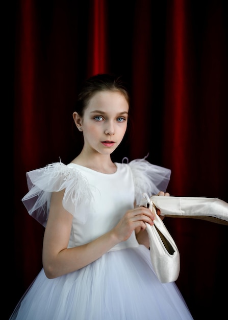 Una linda bailarina con un vestido blanco sobre un fondo rojo Arte Danza Belleza