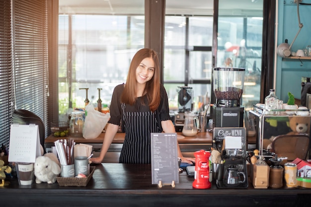 Foto linda barista está sorrindo em sua cafeteria