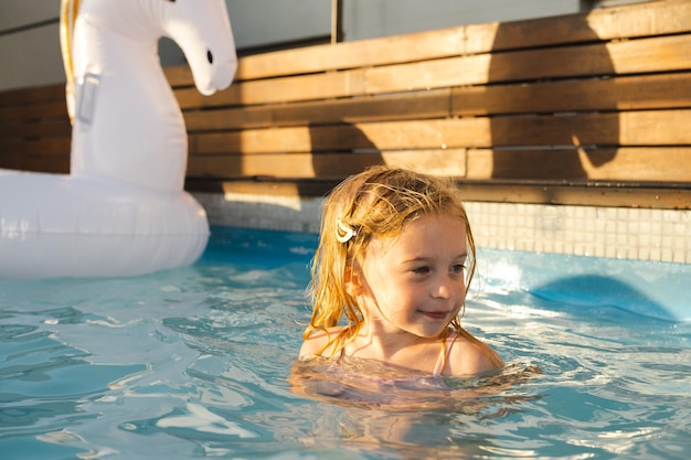 Linda bastante juguetona feliz caucásica rubia niña de dos años childkid niño divirtiéndose con agua