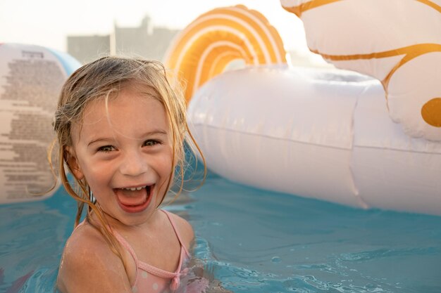 Linda bastante juguetona feliz caucásica rubia niña de dos años childkid niño divirtiéndose con agua