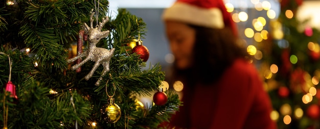 Linda boneca de rena prateada e linda bola de enfeites pendurados na árvore de Natal como decoração de Papai Noel para uma festa noturna brilhante em casa no festival de férias de inverno. Adicione um pouco de ruído para se ajustar à imagem de estilo vintage