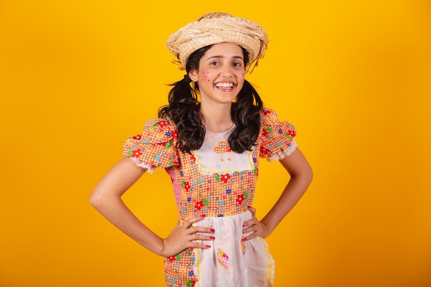 Linda brasileira, com roupa de festa junina, sorrindo e posando para foto.