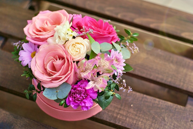 Foto linda caixa rosa redonda com composição de flores de rosas