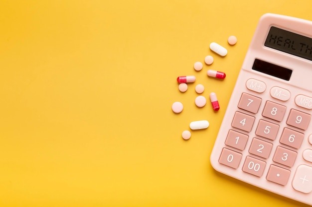 Linda calculadora rosa e vitaminas ou pílulas em um fundo amarelo com um lugar para uma inscrição