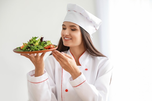 Foto linda chef feminina com salada na cozinha