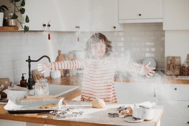 Linda chica de 4 años haciendo galletas navideñas tradicionales