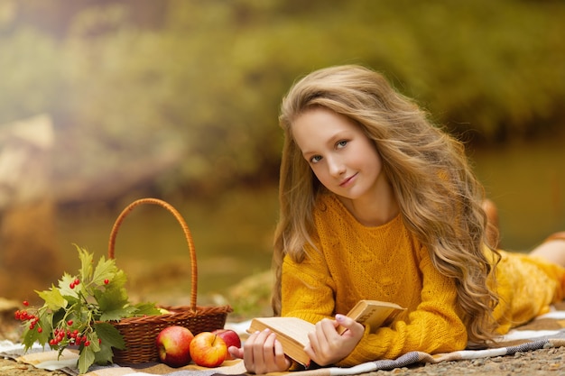 Linda chica adolescente en el bosque de otoño