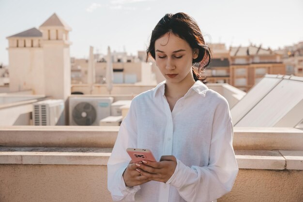 Linda chica adolescente se comunica en el teléfono móvil smartphone