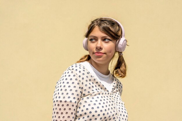 Linda chica adolescente se divierte escuchando música con auriculares