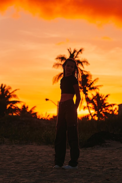 Linda chica adolescente hermosa en la costa tropical al atardecer