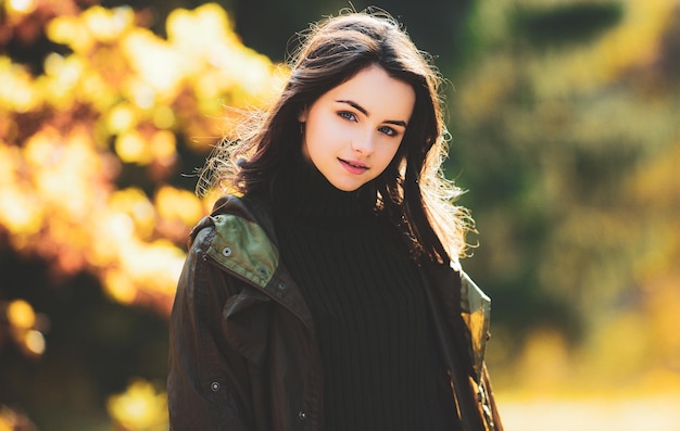 Linda chica adolescente sonriente con hojas sobre fondo de naturaleza caída Otoño adolescente feliz